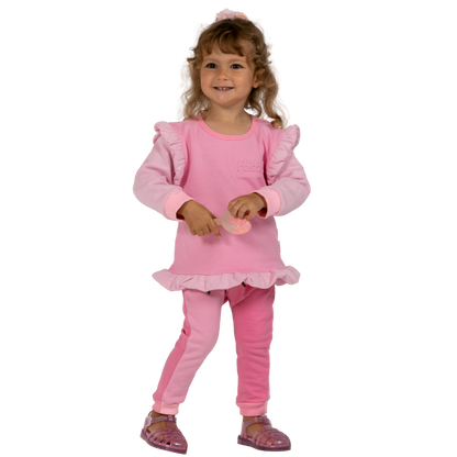 Child wearing a raspberry and candy pink spill resistant outfit with ruffles on a transparent background by Natural Rascals