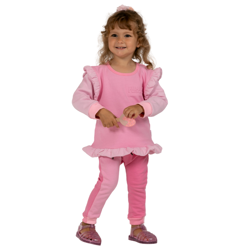 Child wearing a raspberry and candy pink spill resistant outfit with ruffles on a transparent background by Natural Rascals