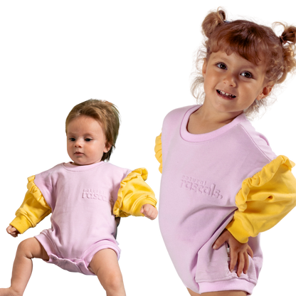Two children wearing matching pastlel lavender and sunshine yellow baby, toddler rompers that are spill resistant by Natural Rascals