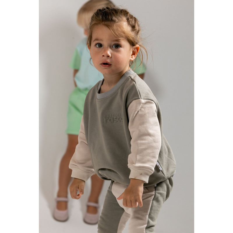 child wearing earthy and oat spill-resistant baby toddler sweat jumper by Natural Rascals.”
