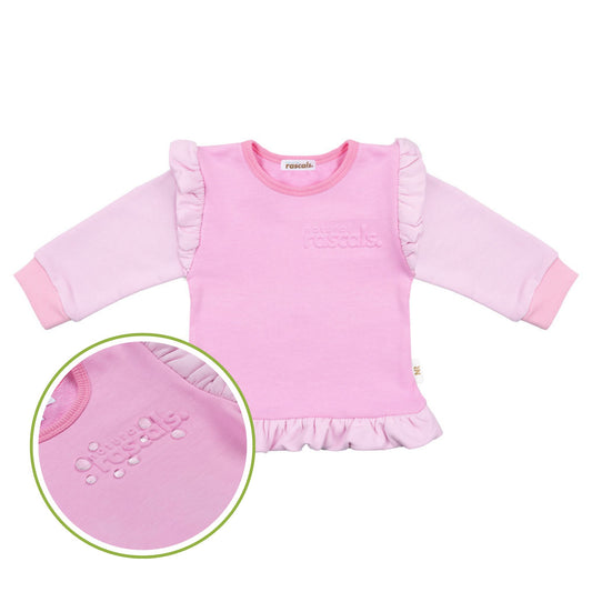 Child wearing a raspberry candy pink spill resistant outfit with ruffled sleeves by Natural Rascals on a transparent background