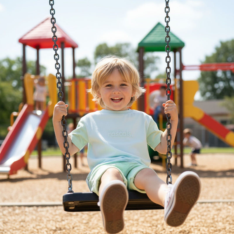 “Child swinging in airy blue and mint green spill-resistant baby toddler tee by Natural Rascals