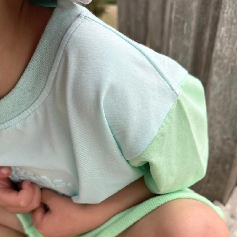 Child wearing a light mint green tee shirt that is zoomed in on quality of Natural Rascals